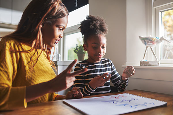 Mother helping daughter do school work